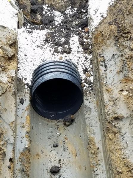  This is a close-up example of the support the spoon on our excavator provides. Also, note the rock we use to provide an extra level of support to ensure the integrity of the pipe.