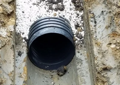 This is a close-up example of the support the spoon on our excavator provides. Also, note the rock we use to provide an extra level of support to ensure the integrity of the pipe.